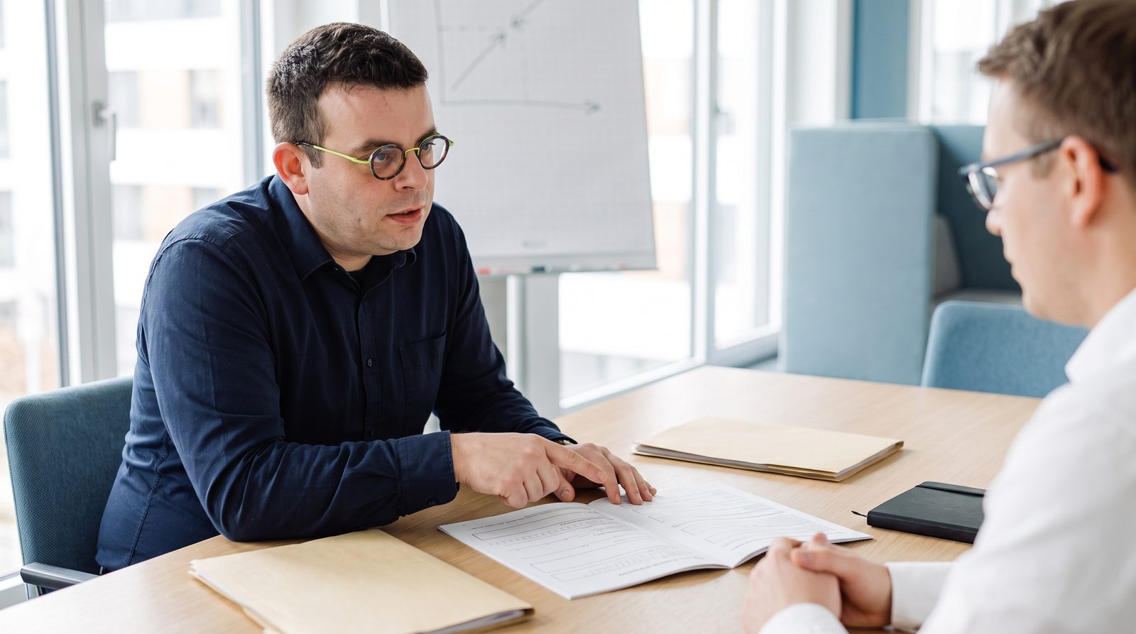 Beratungsgespräch zur Förderung einer KI-Weiterbildung mit Antragsunterlagen