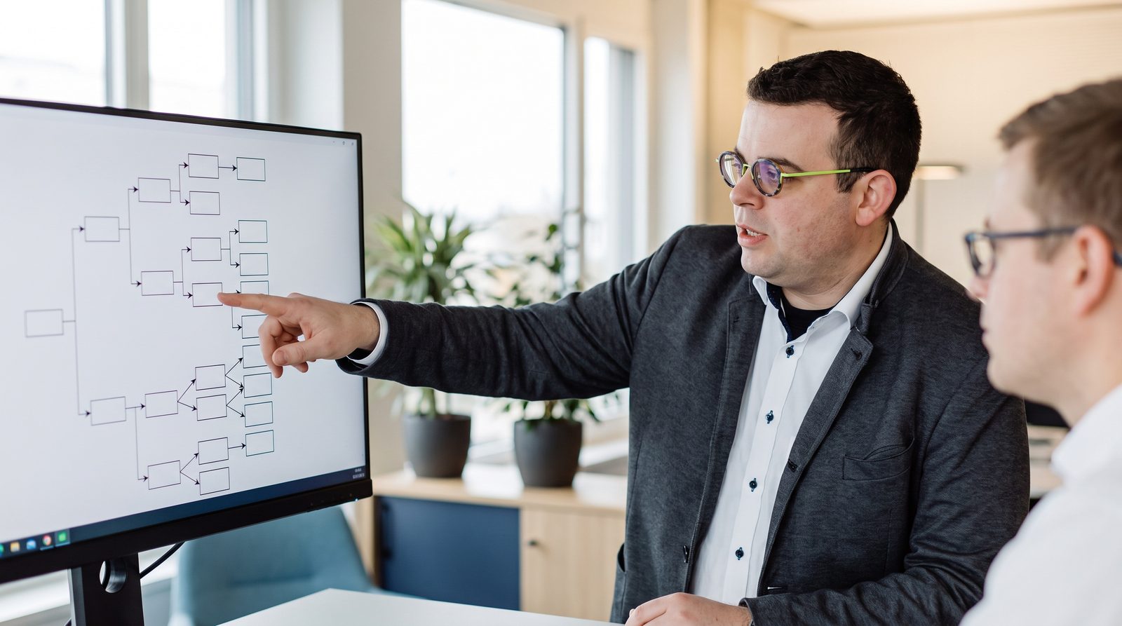 Felix Wilhelm erläutert an einem Ablaufdiagramm die Arbeitsweise eines KI-Agenten