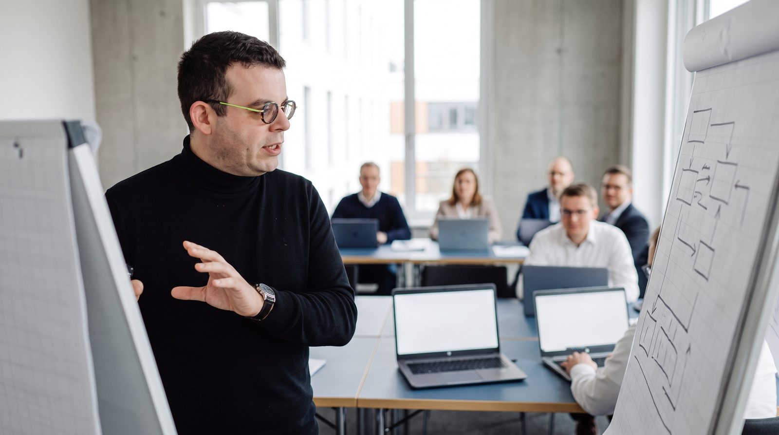 Teilnehmer einer KI-Schulung arbeiten an eigenen Aufgaben