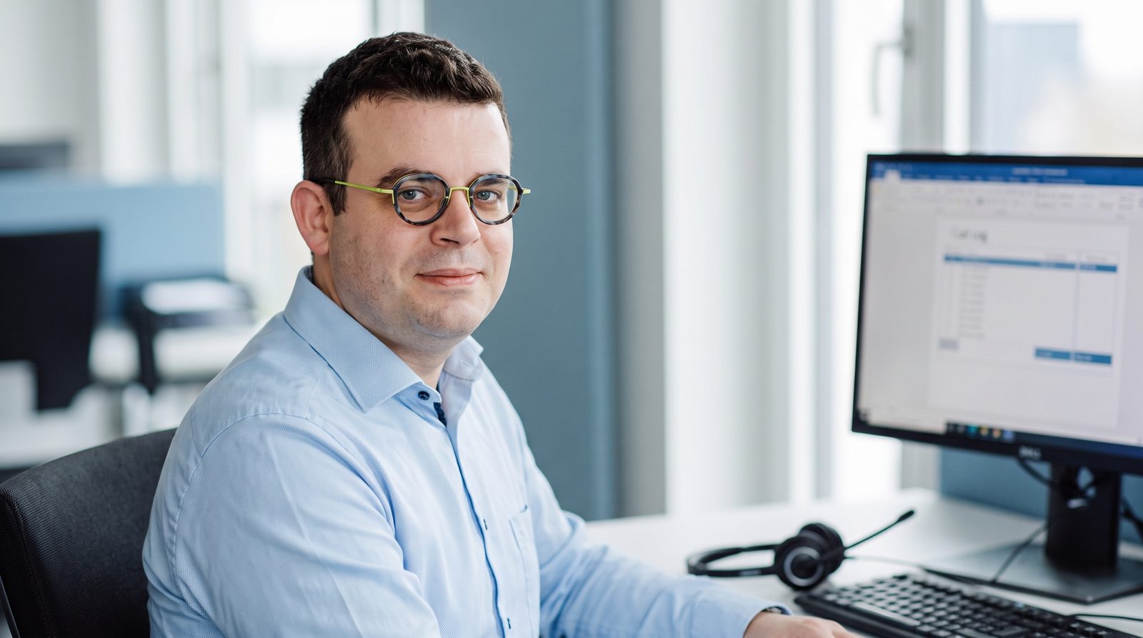 Mitarbeiter mit Headset, am Bildschirm ein Gesprächsablauf